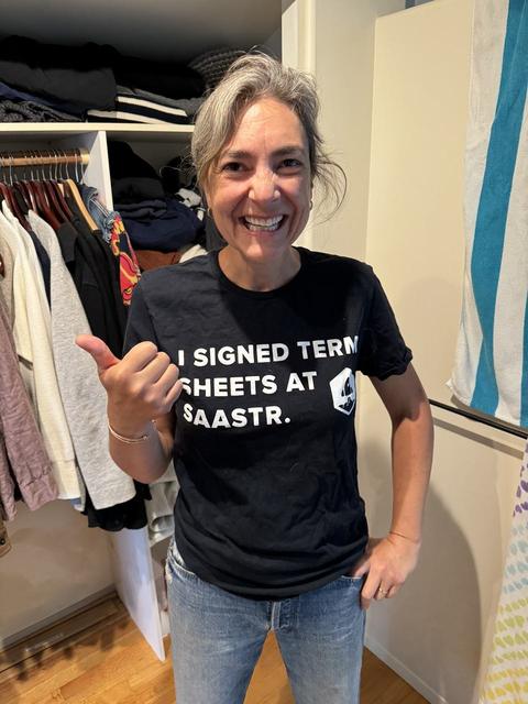 Smiling woman in an I Signed Term Sheets at SaaStr t-shirt