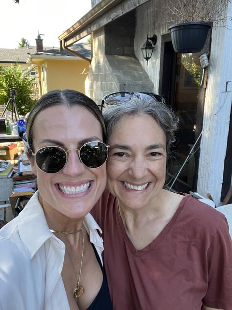 Two women smiling for a selfie outside