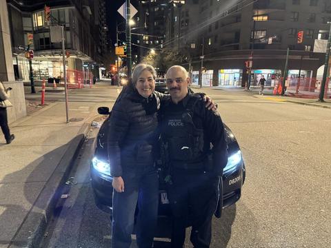 A woman and a police officer on a city street at night