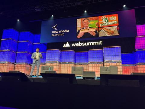 A speaker on the Web Summit main stage under blue lights