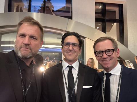 James and two friends in suits at an evening event