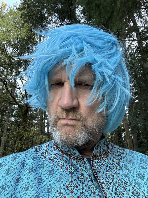 Close-up of James in a shaggy blue wig