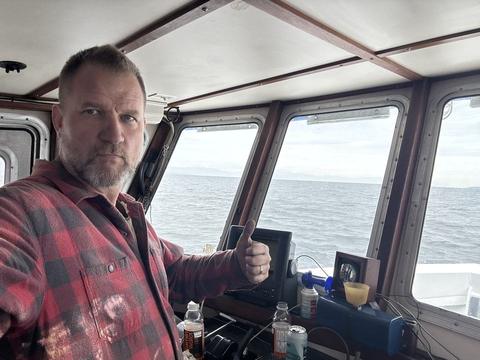 James taking a selfie at the wheel of a fishing boat